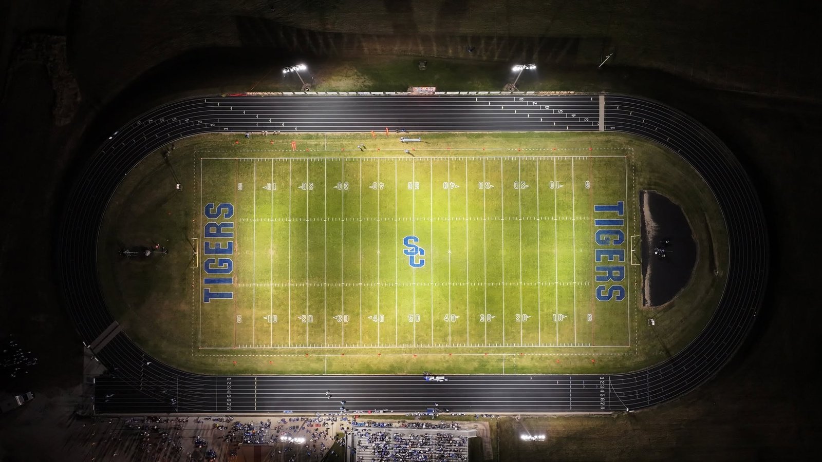 Aerial night view of a high school football stadium during a game