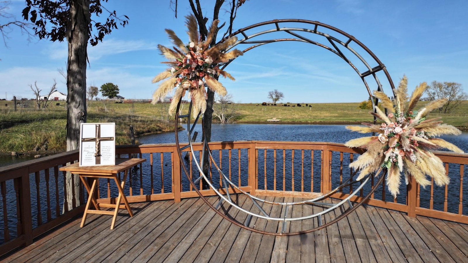 Aerial wedding venue setup with a floral arch overlooking a pond