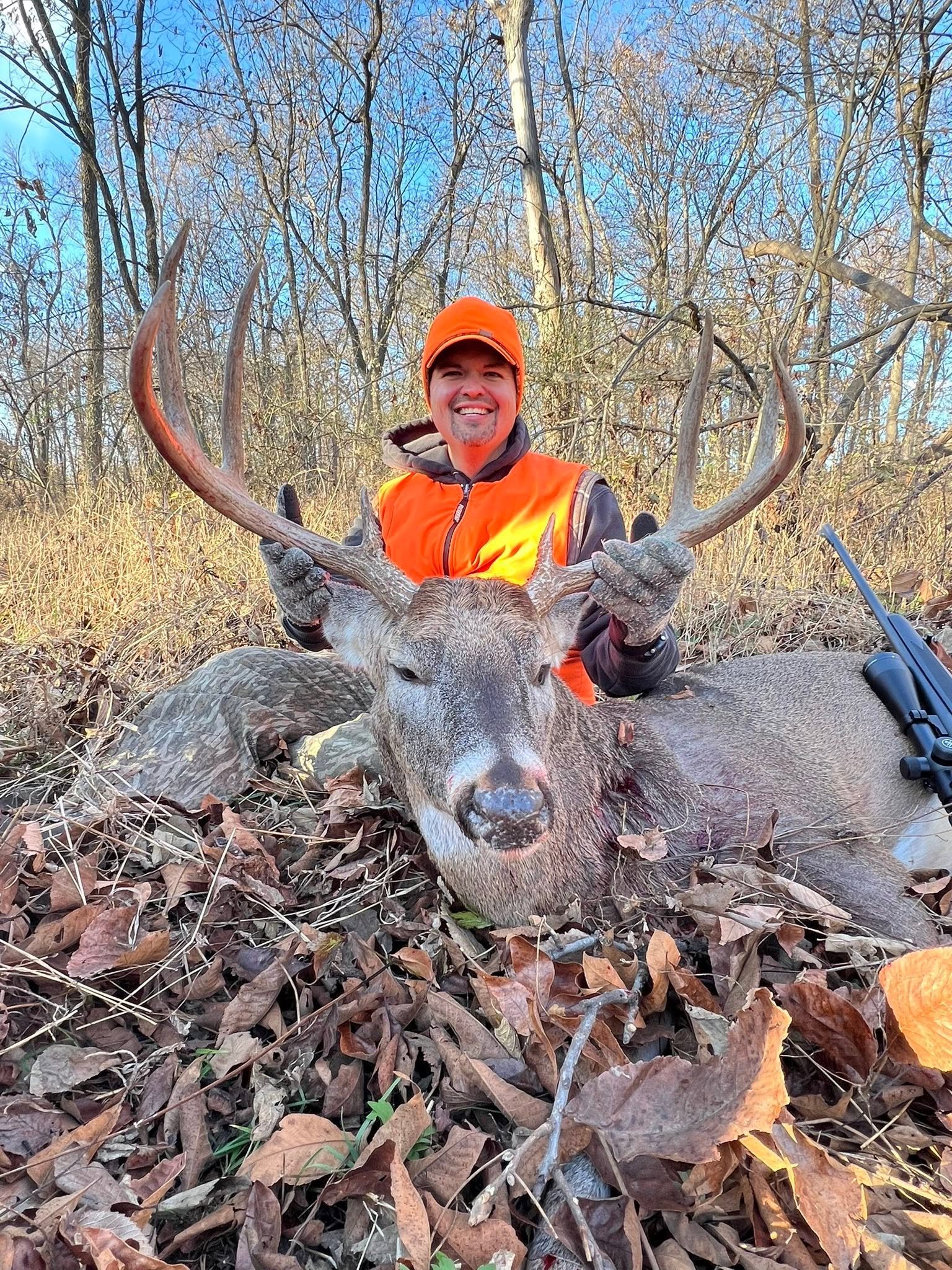 Hunter with a recovered buck on a scenic Missouri overlook