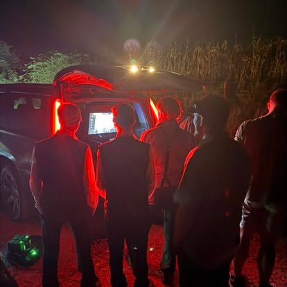 Recon1 crew gathered at the tailgate monitor during a night recovery